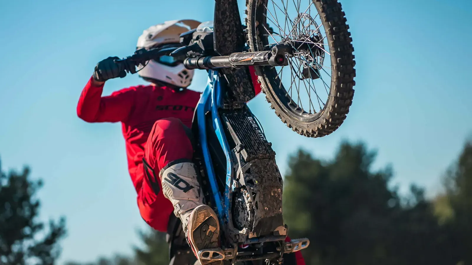 Surron w terenie — wheelie z bijącym spod koła piachem